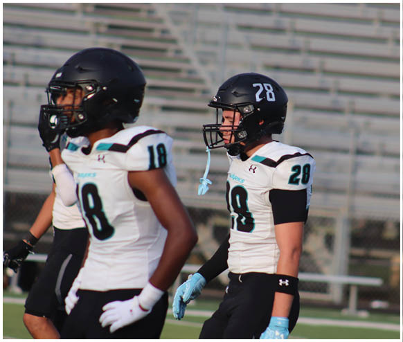 Two football players wearing number 22 and 28. Description generated by AI
