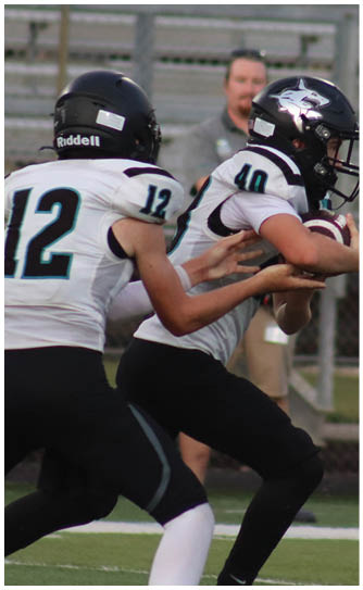 A boy in a white jersey with the number 12 on it is running on a field. Description generated by AI