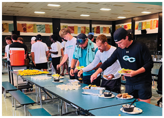 A group of people are serving themselves food from a buffet table. Description generated by AI