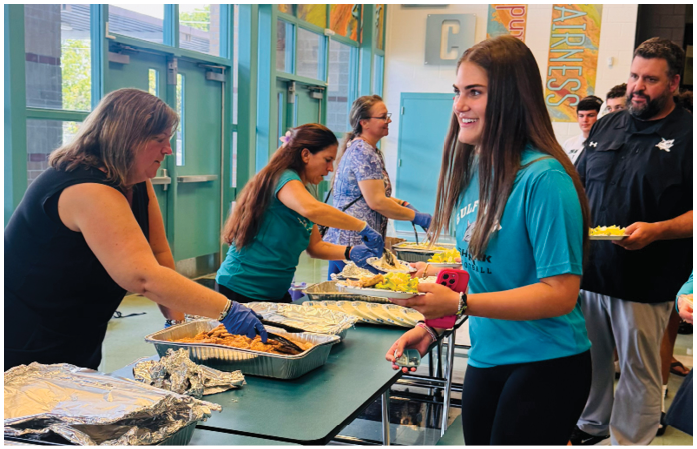 A group of people are serving food at a buffet. Description generated by AI
