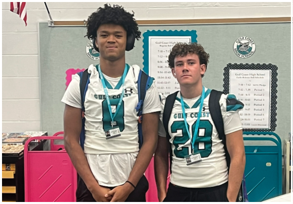 Two young men wearing football jerseys. Description generated by AI