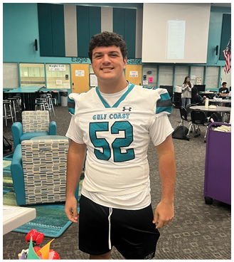 A man wearing a football jersey with the number 52. Description generated by AI