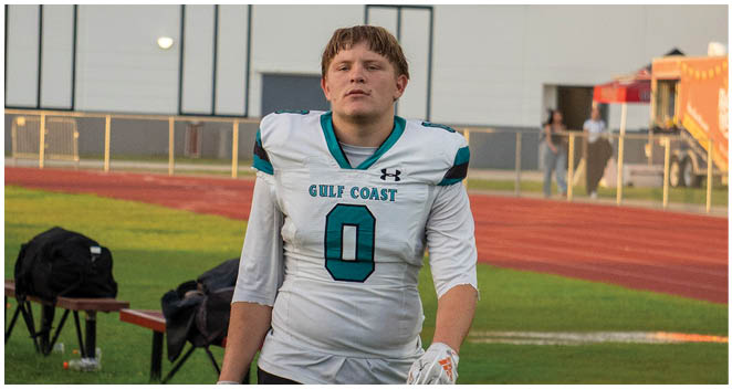 A football player wearing a white jersey with the number 0 on it. Description generated by AI