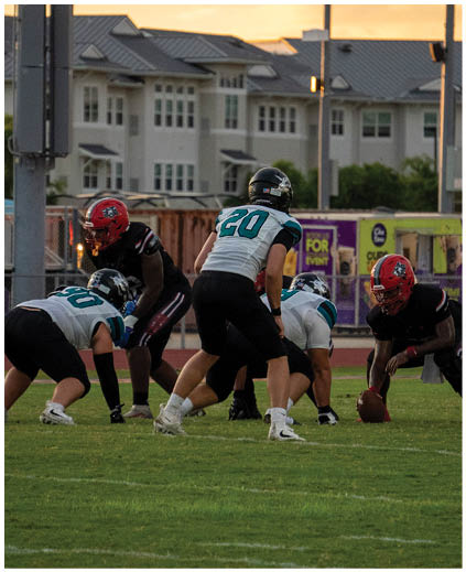 A group of football players on a field. Description generated by AI