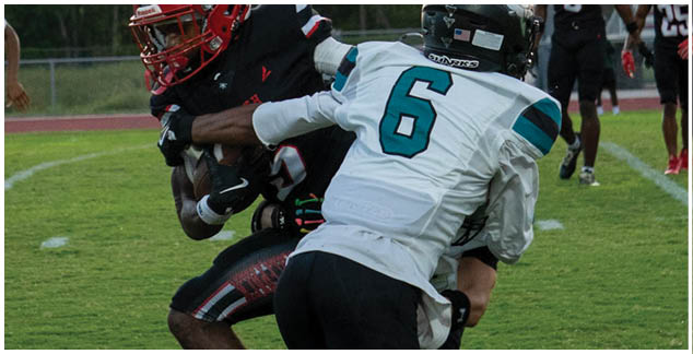 Two football players are on the field, one is wearing a white jersey and the other is wearing a black jersey. Description generated by AI