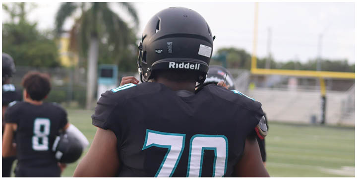 A football player wearing a black and blue jersey with the number 70 on it. Description generated by AI