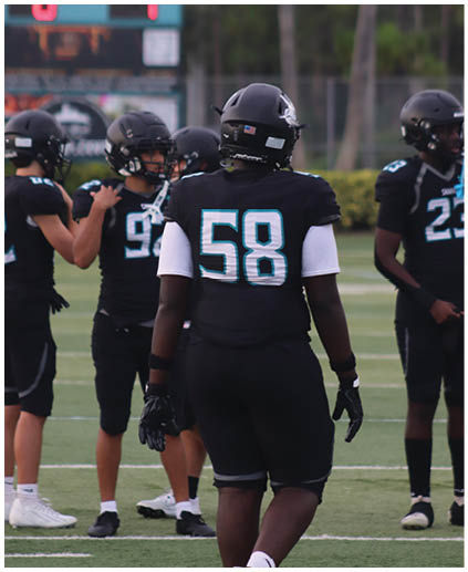 A group of football players standing on a field. Description generated by AI