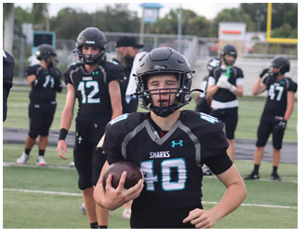 A football player wearing a black jersey with the number 2 on it. Description generated by AI