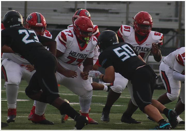 A group of football players in black and white uniforms on a field. Description generated by AI