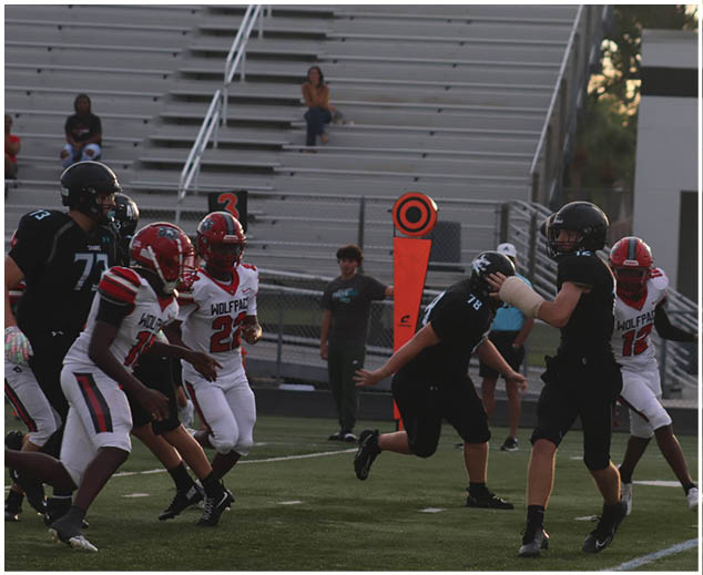A group of football players on a field. Description generated by AI