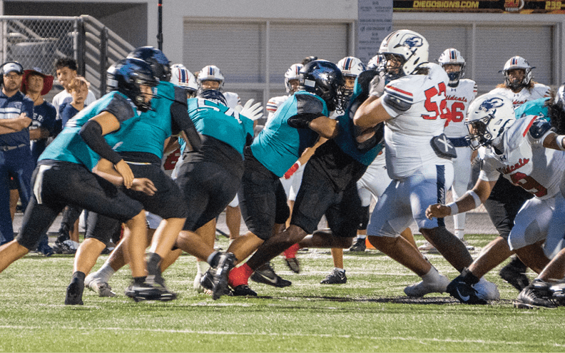 A group of football players on a field. Description generated by AI