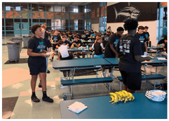 A group of people are sitting at tables in a cafeteria. Description generated by AI
