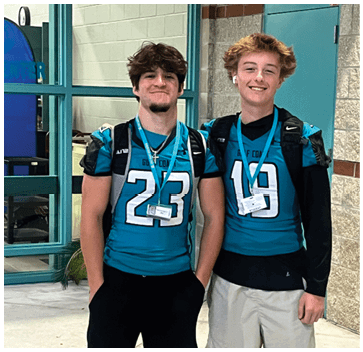 Two young men wearing blue and white jerseys. Description generated by AI