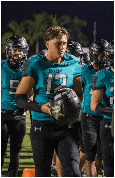 A football player wearing a blue and black uniform. Description generated by AI