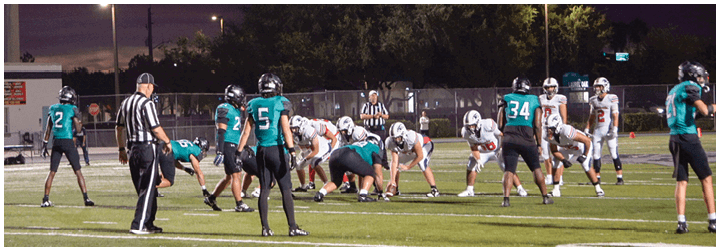 A group of football players on a field. Description generated by AI