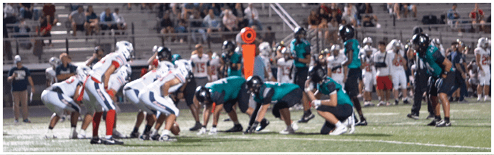 A group of people playing football on a field. Description generated by AI