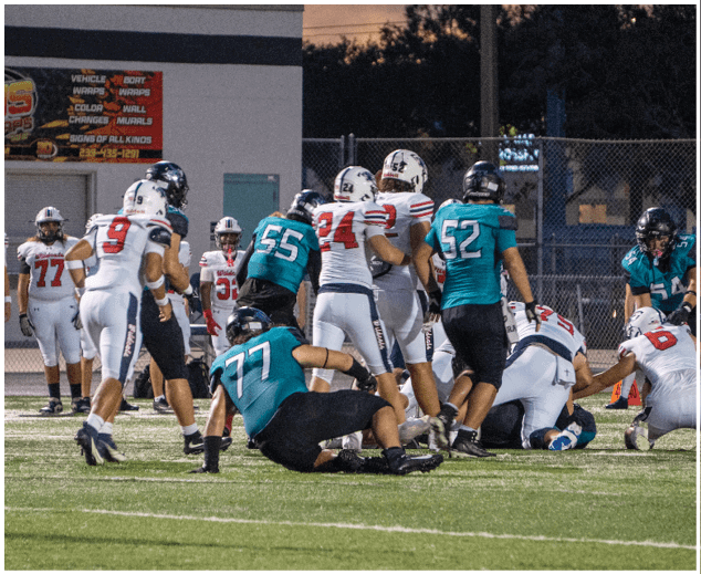 A group of football players on a field. Description generated by AI