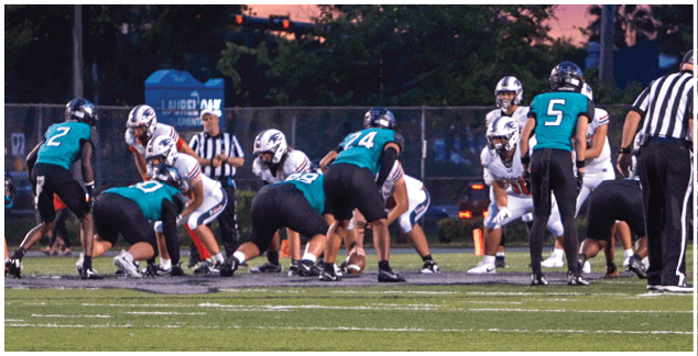 A group of football players on a field. Description generated by AI
