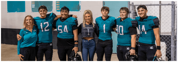 A group of football players posing for a picture. Description generated by AI