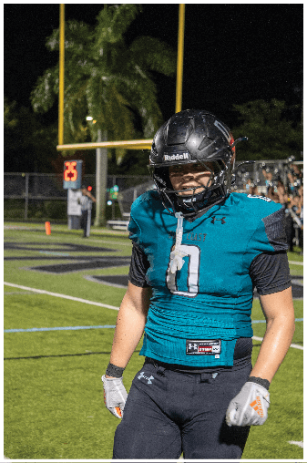 A football player wearing a blue and black jersey. Description generated by AI