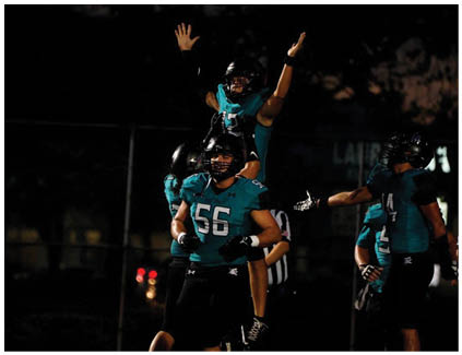 A group of football players celebrating a touchdown. Description generated by AI
