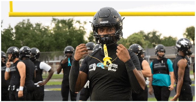 A football player wearing a black jersey with the number 34 on it. Description generated by AI