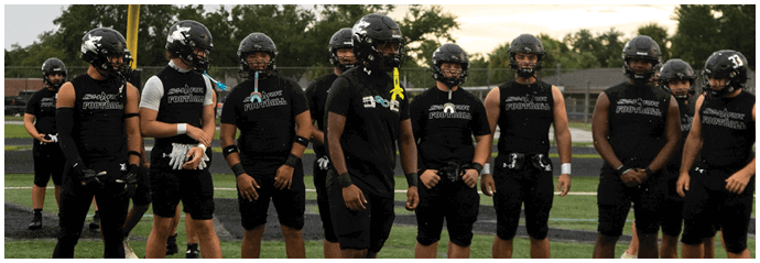 A group of football players standing on a field. Description generated by AI