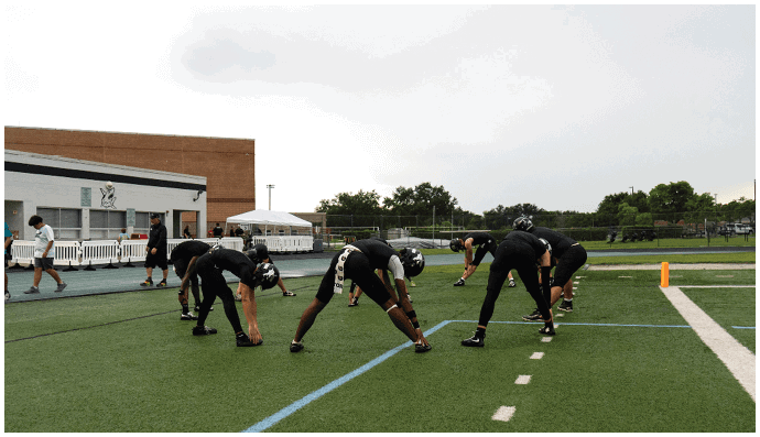 A group of football players on a field. Description generated by AI