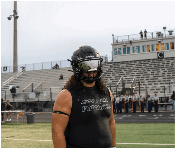 A man wearing a football helmet and jersey. Description generated by AI