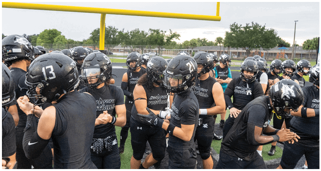 A group of football players wearing black uniforms. Description generated by AI