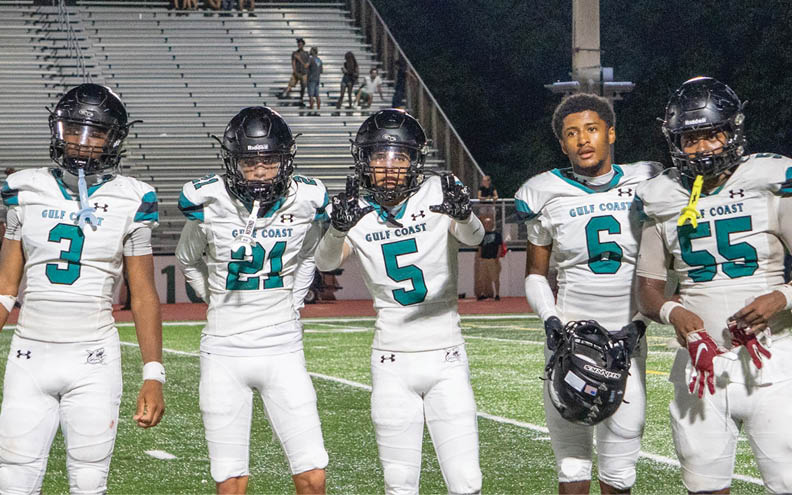 A group of football players on a field. Description generated by AI