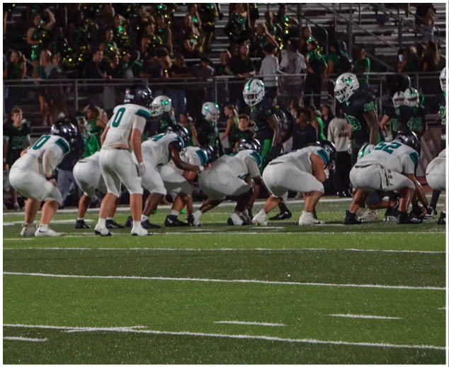A group of football players on a field. Description generated by AI