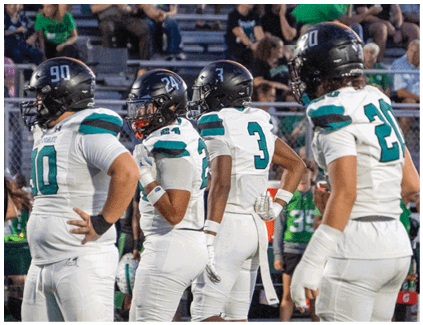 A group of football players on a field. Description generated by AI