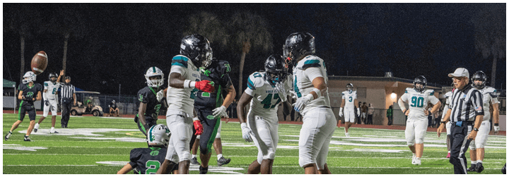 A group of football players posing for a picture. Description generated by AI