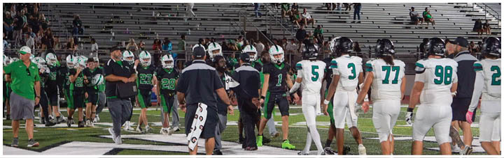 A group of football players on a field. Description generated by AI