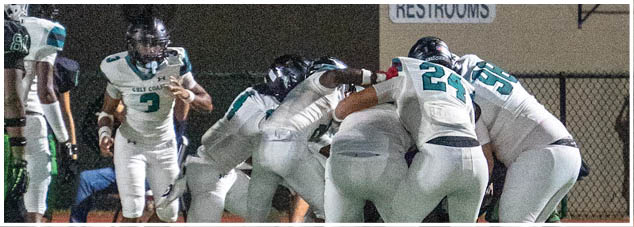 Two football players standing on a field. Description generated by AI