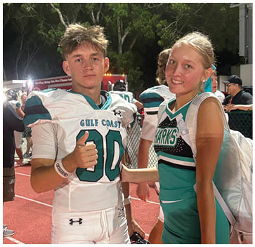 Two young men wearing blue and white jerseys. Description generated by AI