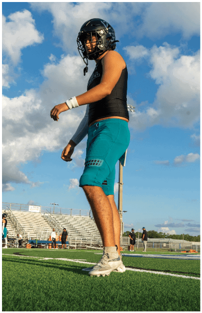 A football player wearing a blue and black uniform. Description generated by AI