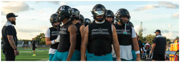 A group of football players on a field. Description generated by AI