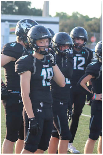 A football player wearing a blue and black jersey. Description generated by AI