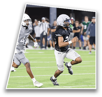 Two people wearing athletic clothing are running on a green sports field with white yard lines. Description generated by AI