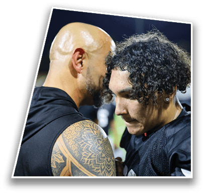 Two people in sports uniforms are closely interacting, with one showing a detailed tattoo on their arm, suggesting a moment of focus or communication during a game. Description generated by AI