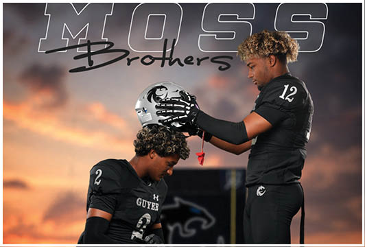 Two people in black football uniforms with curly hair are interacting, with one placing a helmet on the other's head against a sunset background and the words “MOSS Brothers" above them. Description generated by AI