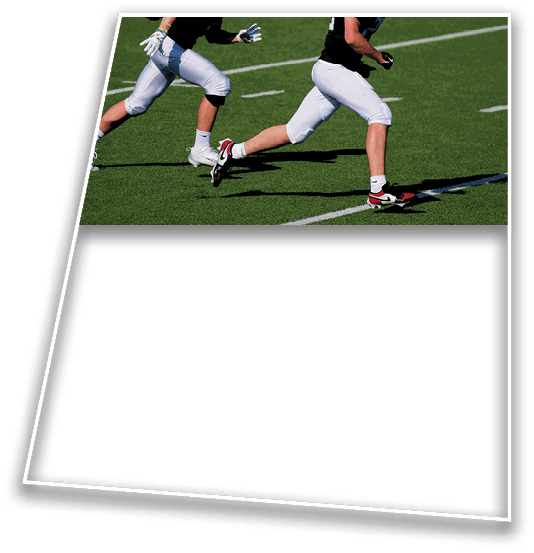 Two people wearing athletic clothing and cleats are running on a green sports field marked with white lines. Description generated by AI