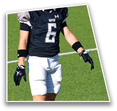 A person wearing a silver football helmet and black sports jersey stands on a green football field with white yard lines. Description generated by AI