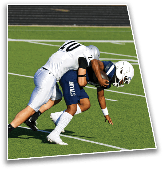 Two people in football uniforms are engaged in a tackle on a green field with white yard lines. Description generated by AI