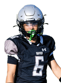 A person wearing a football uniform with a helmet and gloves is standing on a green field. Description generated by AI