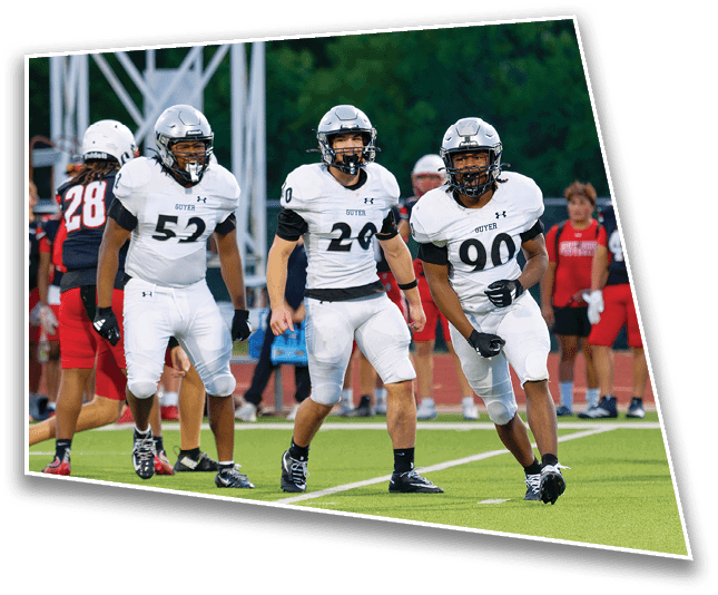 Three people in white football uniforms and helmets are on a field preparing for a play while others in red uniforms stand in the background. Description generated by AI