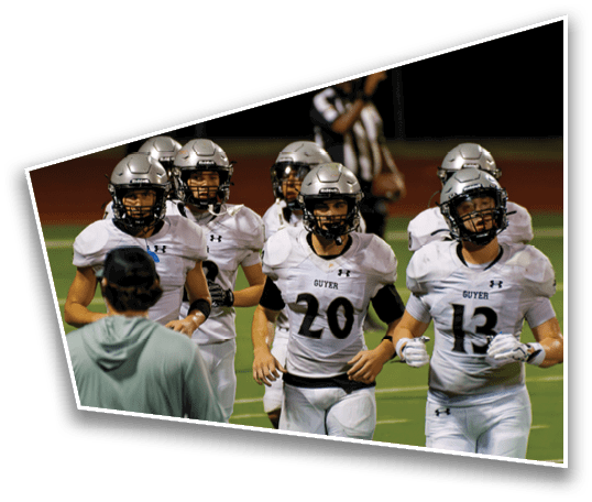 A group of people wearing white football uniforms and helmets are walking together on a green field during a game. Description generated by AI