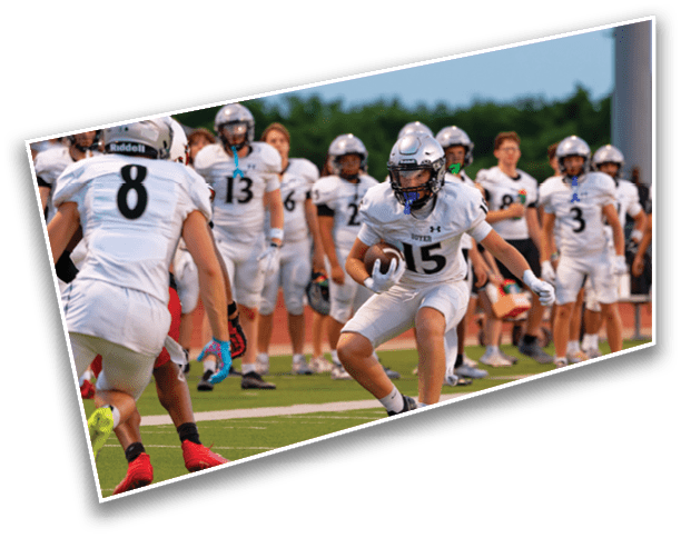 People in football uniforms are playing on a field with one person running with the ball while others prepare to block or tackle. Description generated by AI
